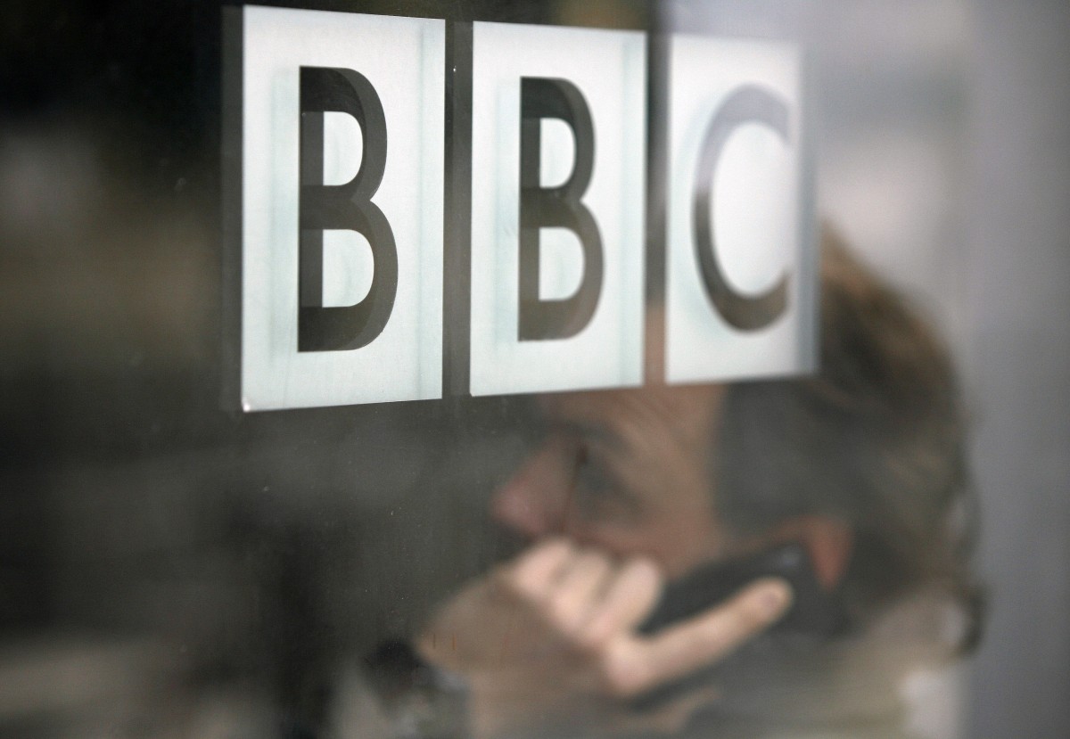 FILE PHOTO: A man talks on a mobile phone inside the BBC headquarters in London November 21, 2008. Credit: REUTERS/Andrew Winning/File Photo