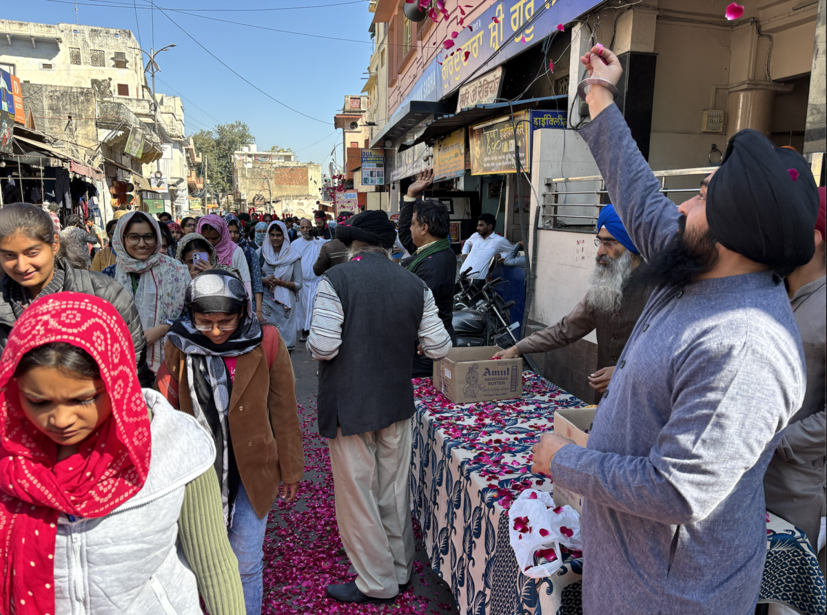 Shopkeepers showering flowers at those marching in the sadbhavna yatra.