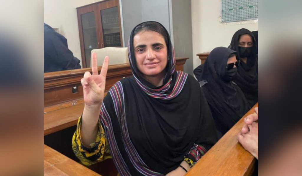 Mahrang Baloch flashes a 'V' sign at the camera during her court appearance.
