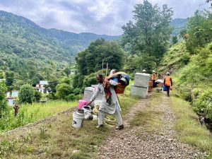 A resident of Kalaban carrying some bedding and utensils which he retrieved from the debris of his home in Kalaban village. (Photo: Nazim Ali Manhas)
