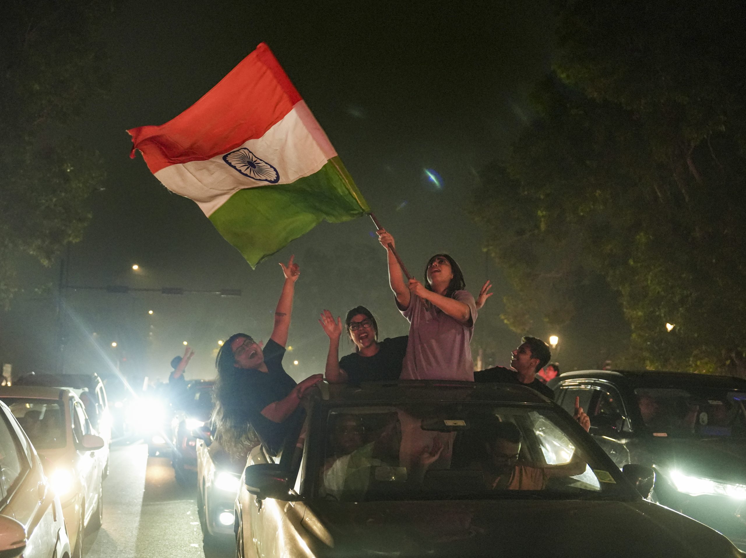 A girl holding a flag on the streets of Delhi after Indian women cricket team won the World Cup 2025.