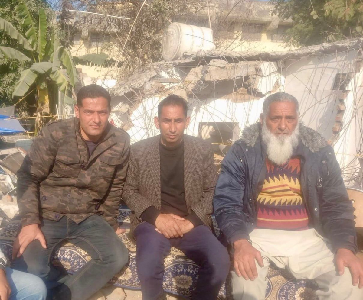 Ghulam Qadir Daing (left), his son Arfaz Ahmad Daing (right) and another person in front of the ruins of their home in Jammu.