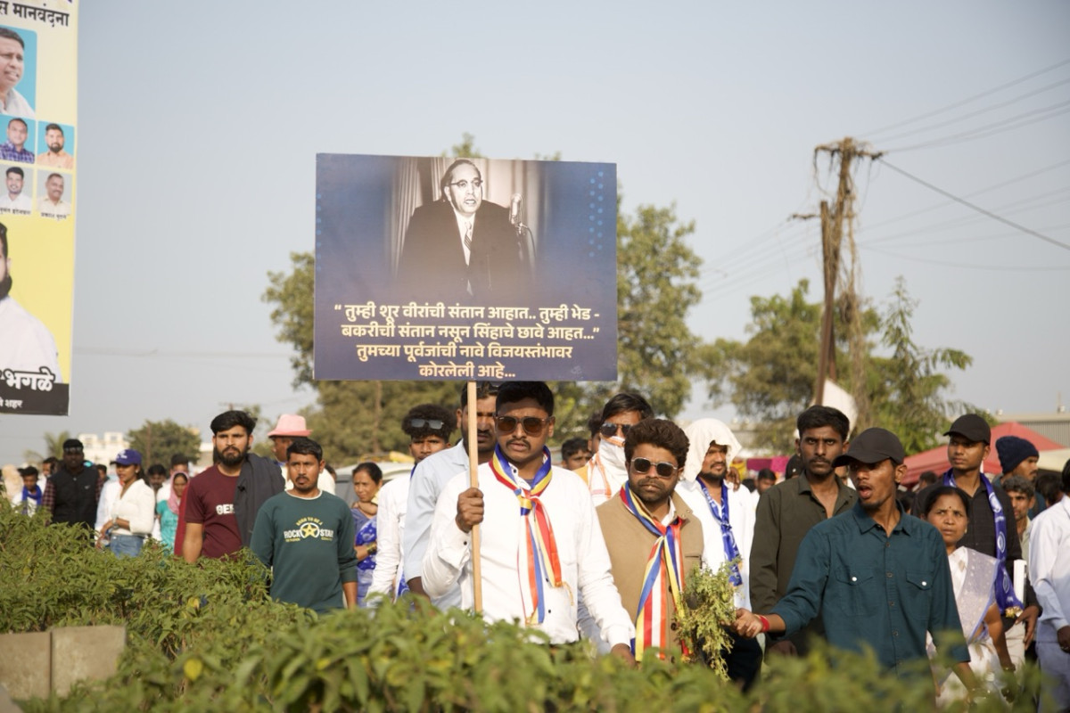 An individual holds a banner of B.R. Ambedkar at the Bhima Koregaon ground near Jaystambh, Pune district, Maharashtra.