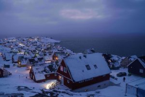 Houses covered by snow are seen on the coast of a sea inlet of Nuuk, Greenland,