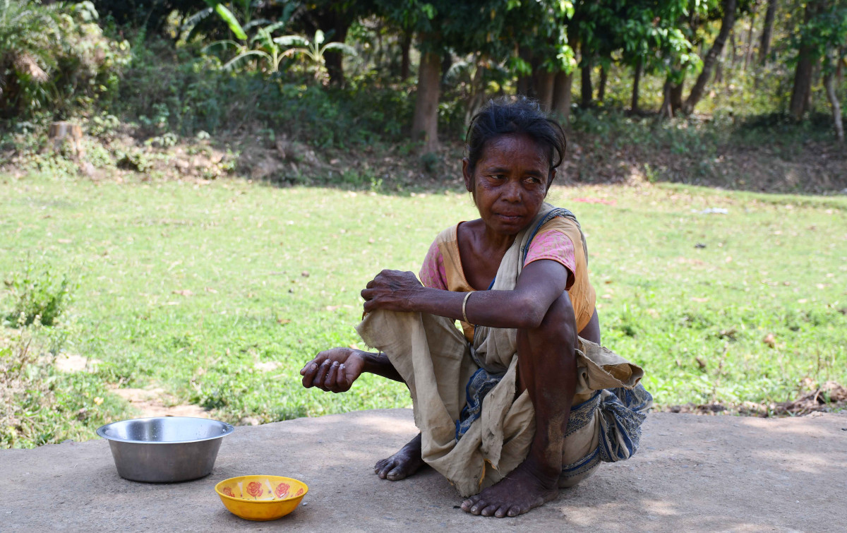 An elderly woman of the Shabar community sits with an empty bowl in Raibandh, Bankura. Photo: Madhu Sudan Chatterjee