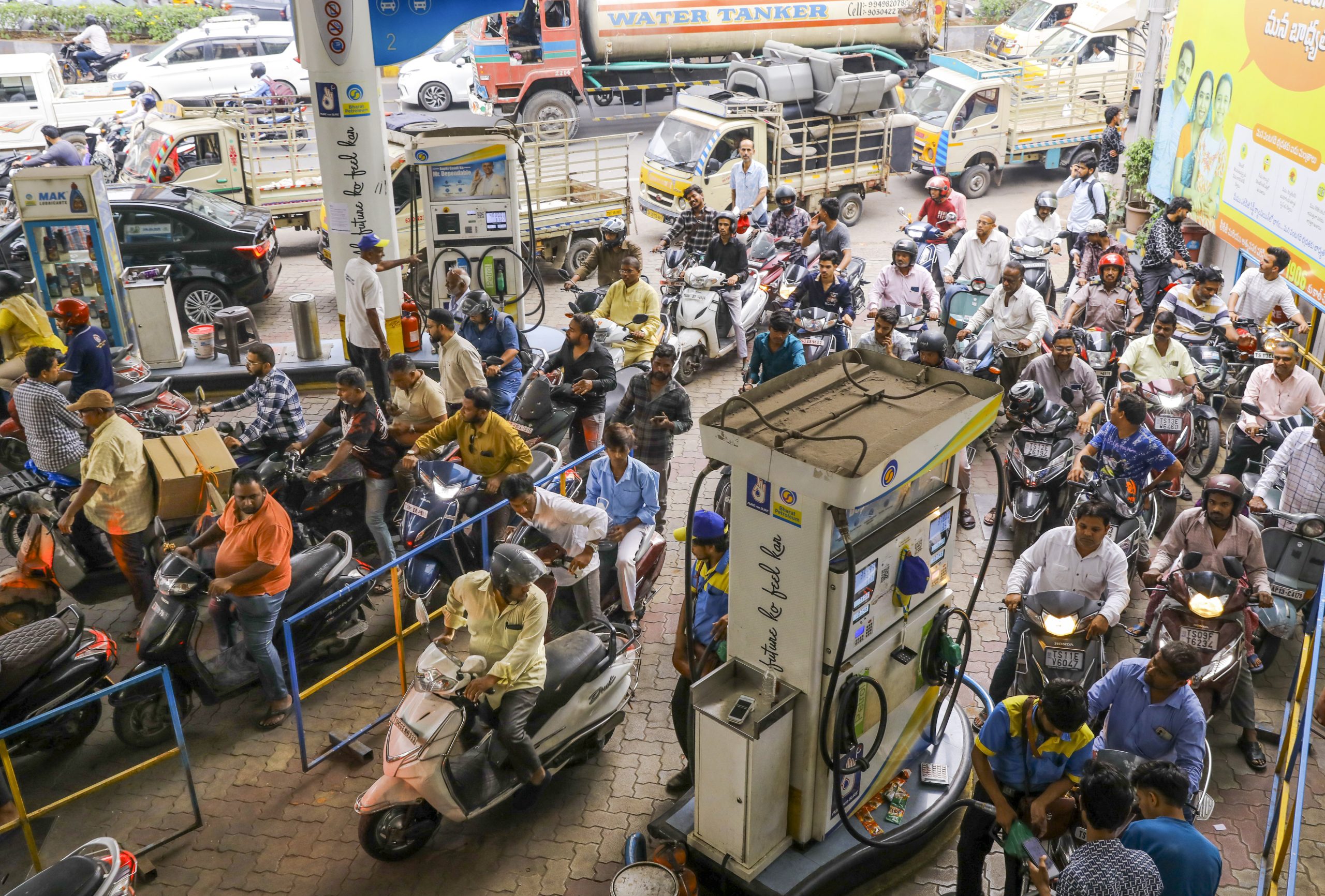 People and vehicles at a petrol pump in Hyderabad.