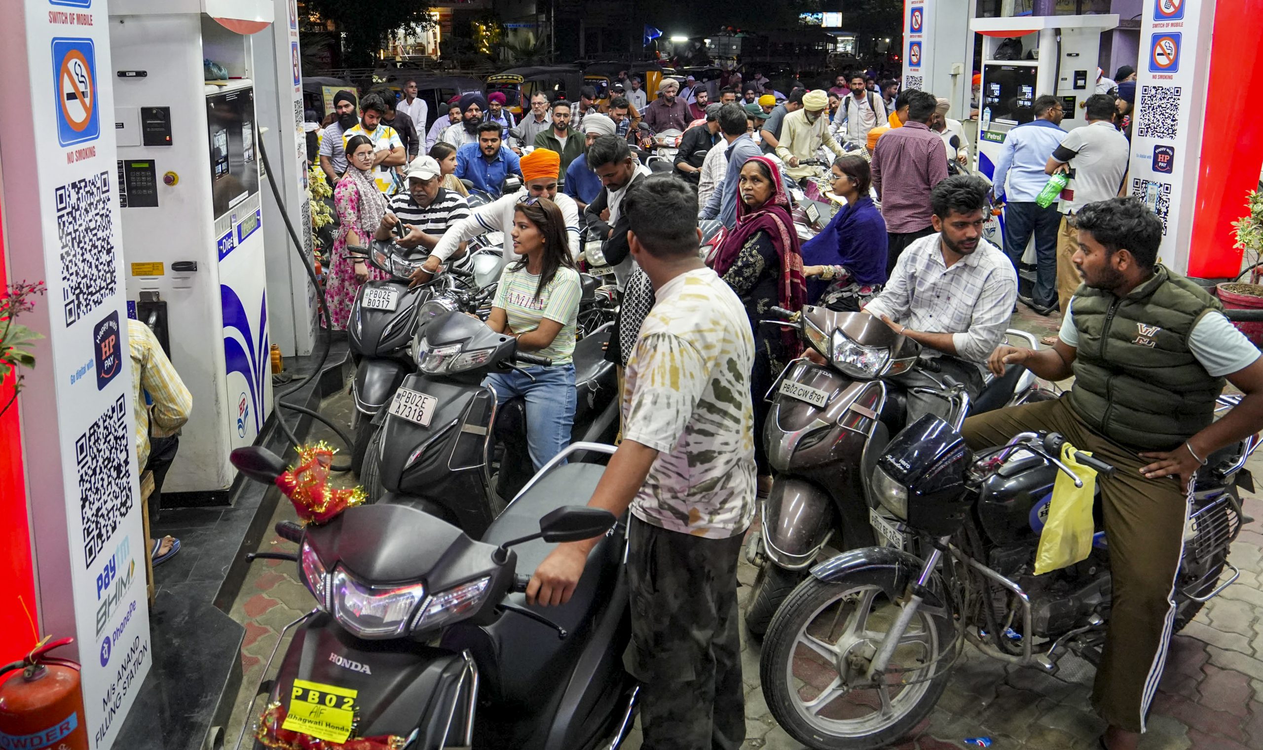 People gather at a petrol pump in Amritsar, Punjab. 