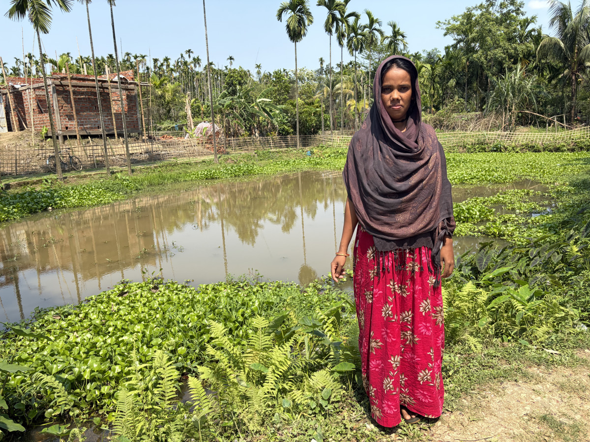 A woman in front of a pond in Hailakandi, Assam.
