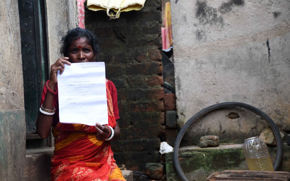Patuli Sarbabedia, a resident of Shitla village in Barjora who was denied the benefits, shows her Annapurna Yojana documents. Photo: Madhu Sudan Chatterjee